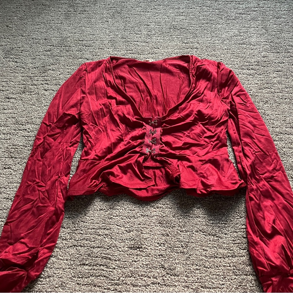 a medium, red, cropped long sleeve with clasps in the middle. lightly worn.